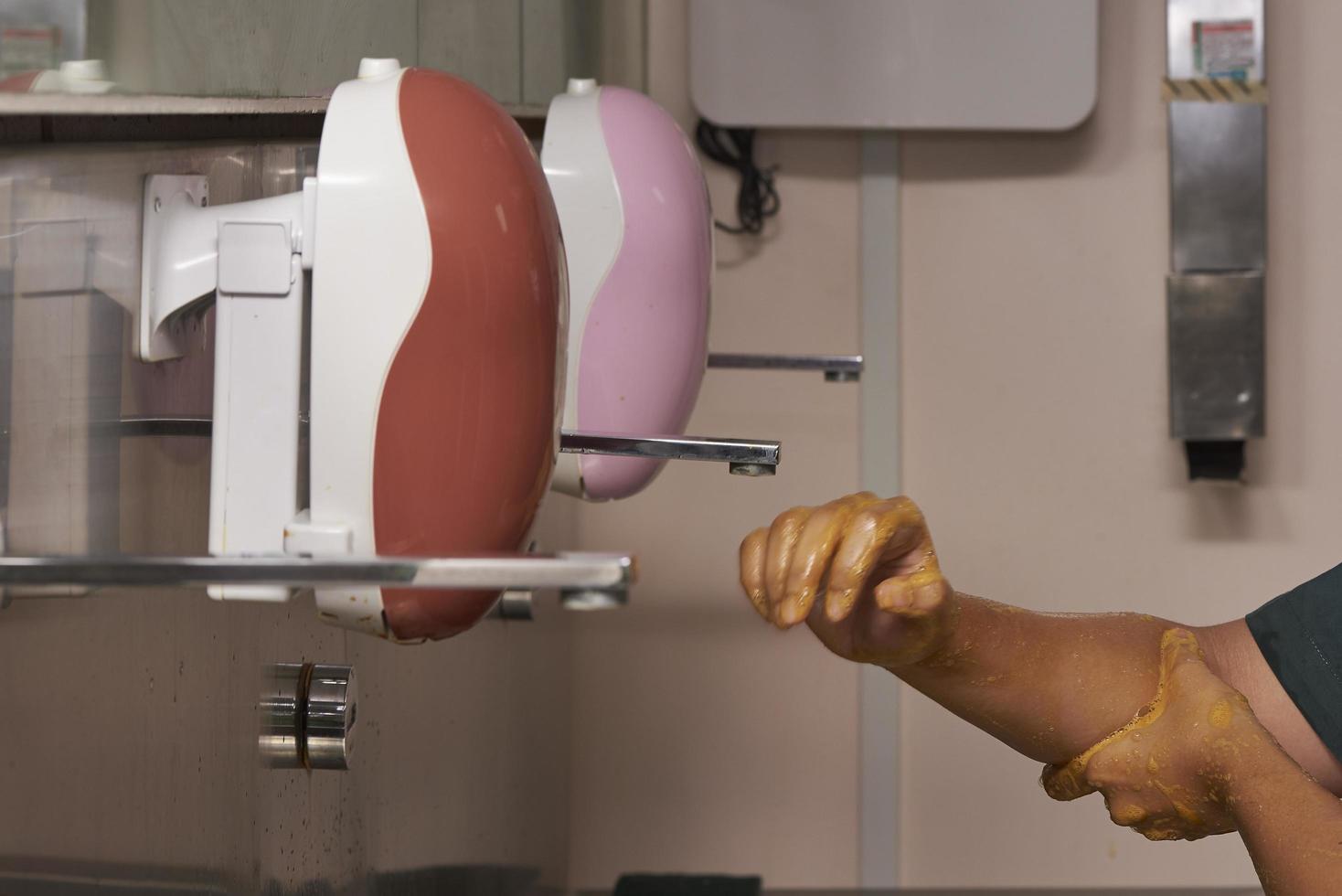 Surgeon scrubbing hands in operating room photo