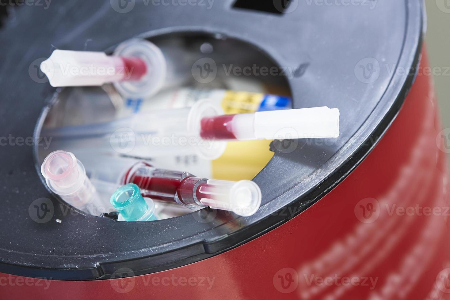 Sharp needles in biohazard container bin photo