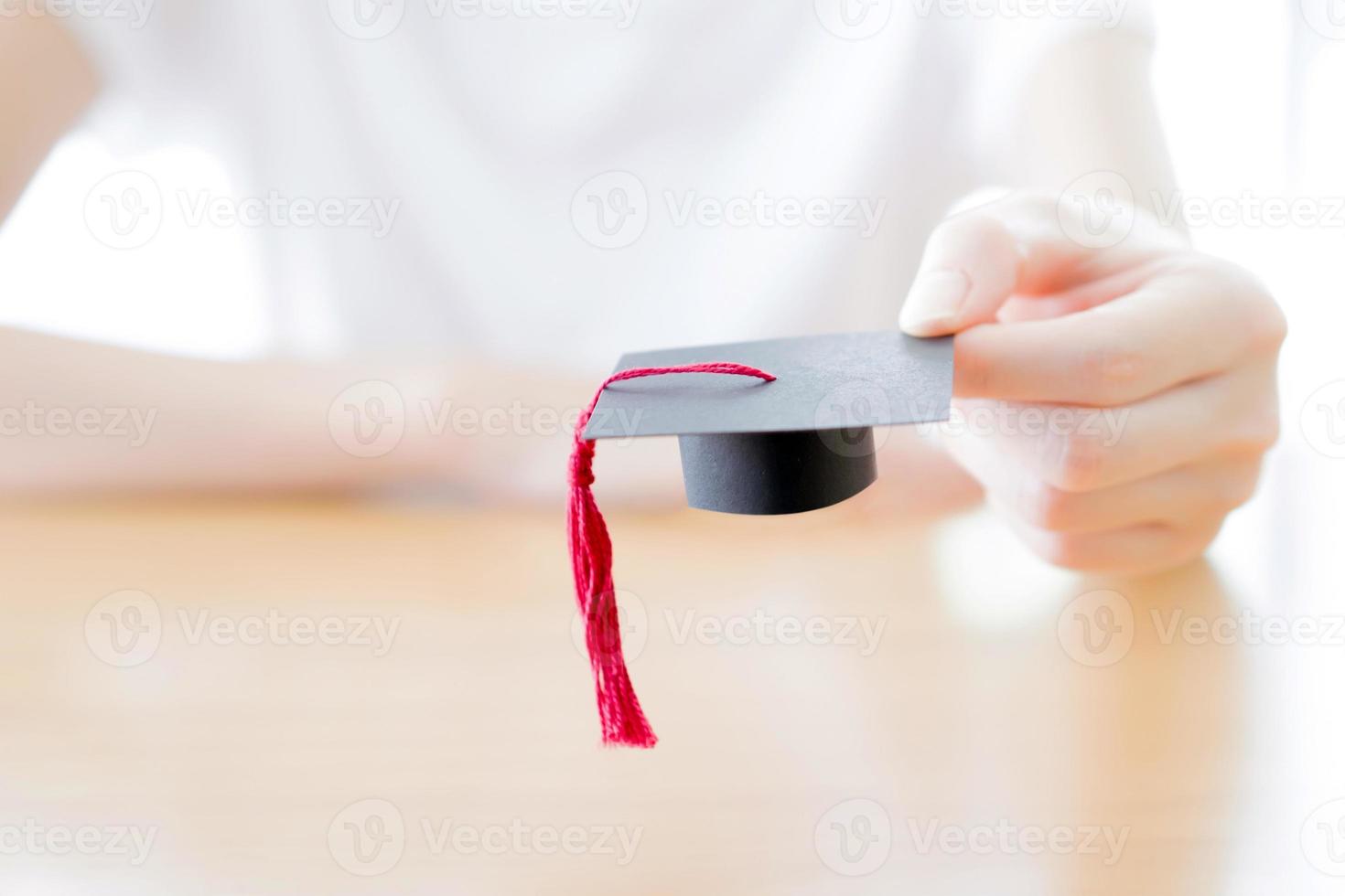 mujer sosteniendo gorro de graduación foto