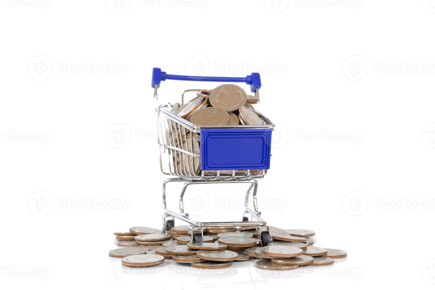 mini carro de compras con monedas sobre fondo blanco foto