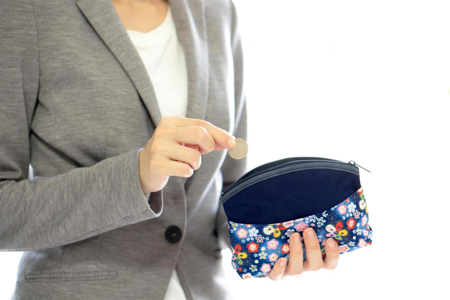 Businesswomen hands holding british coin and small money pouch photo