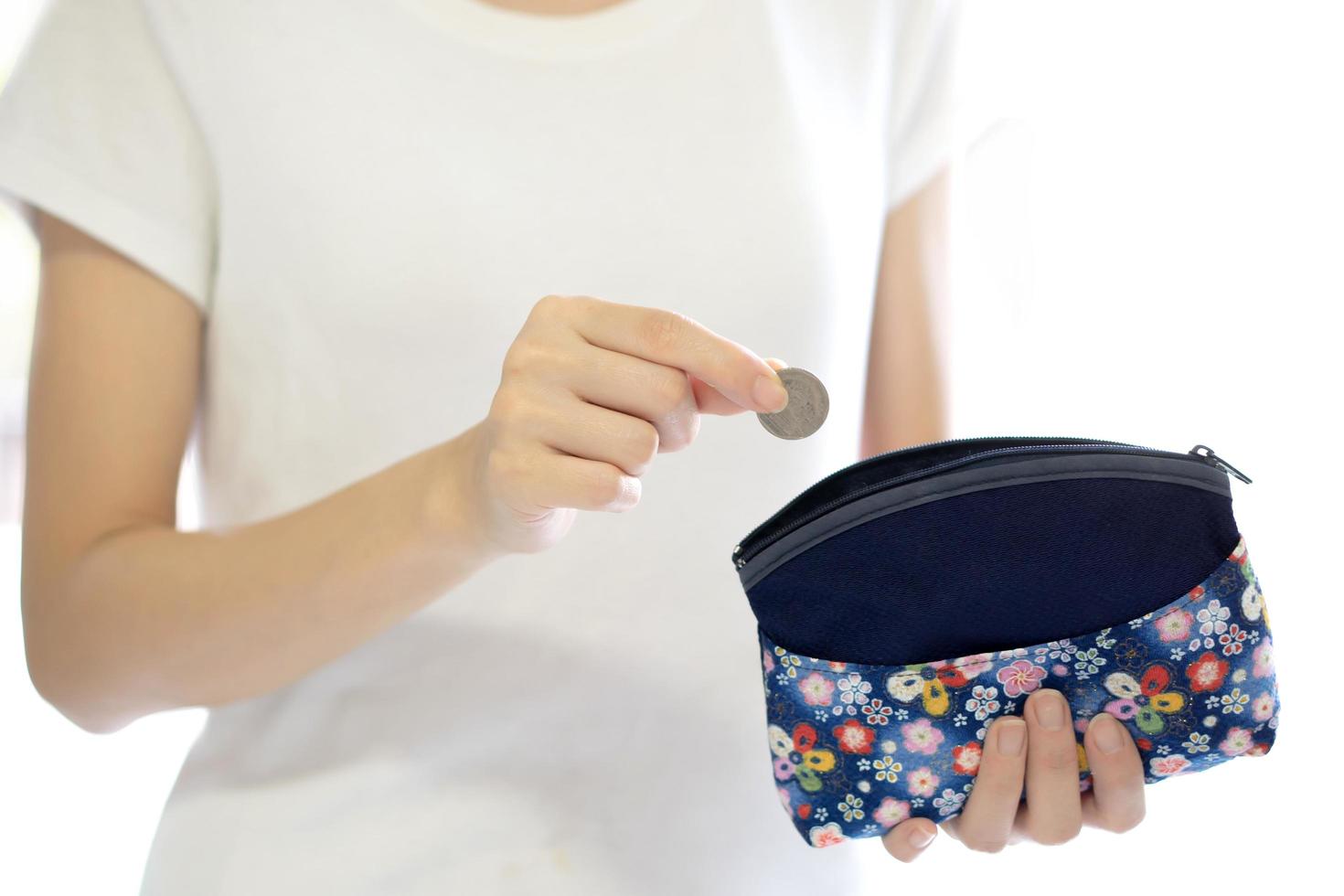 Hands holding british coin and small money pouch photo