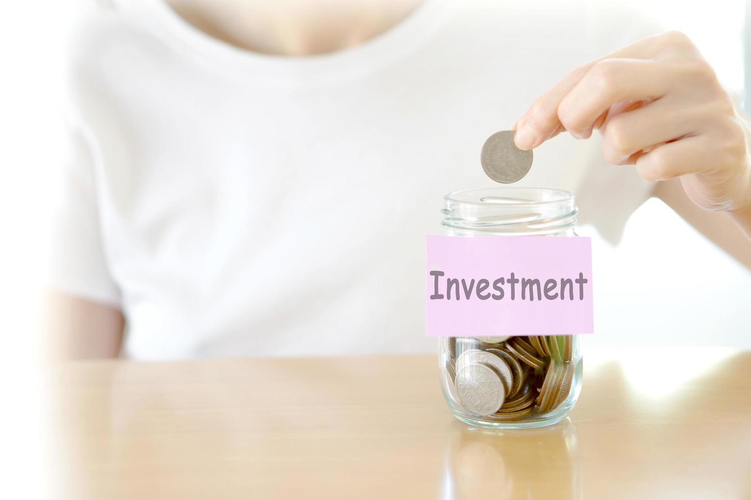 Woman hands with coins in glass jar, close up photo