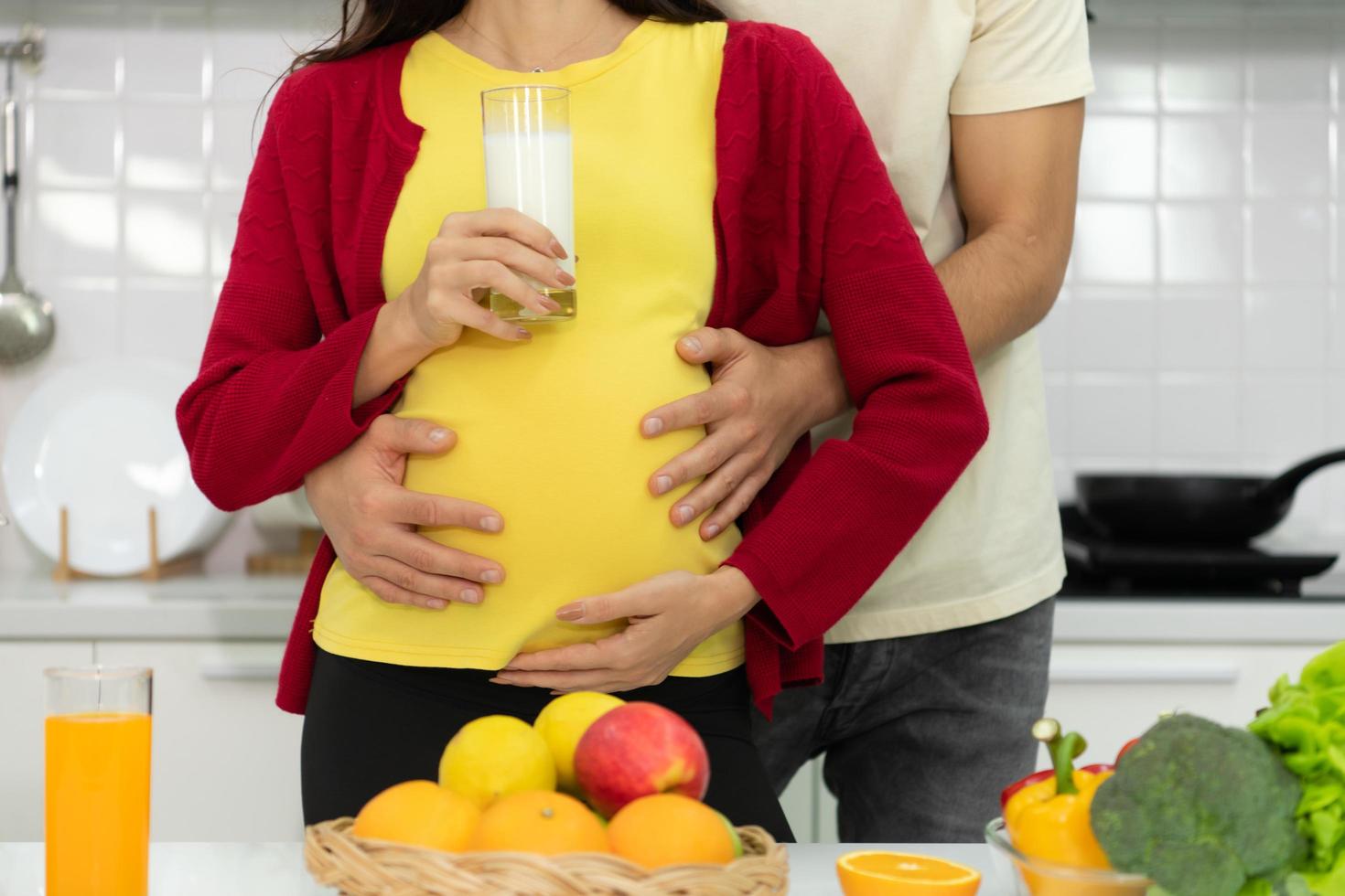Pregnant woman in kitchen with the atmosphere of cooking with the husband to eat together photo