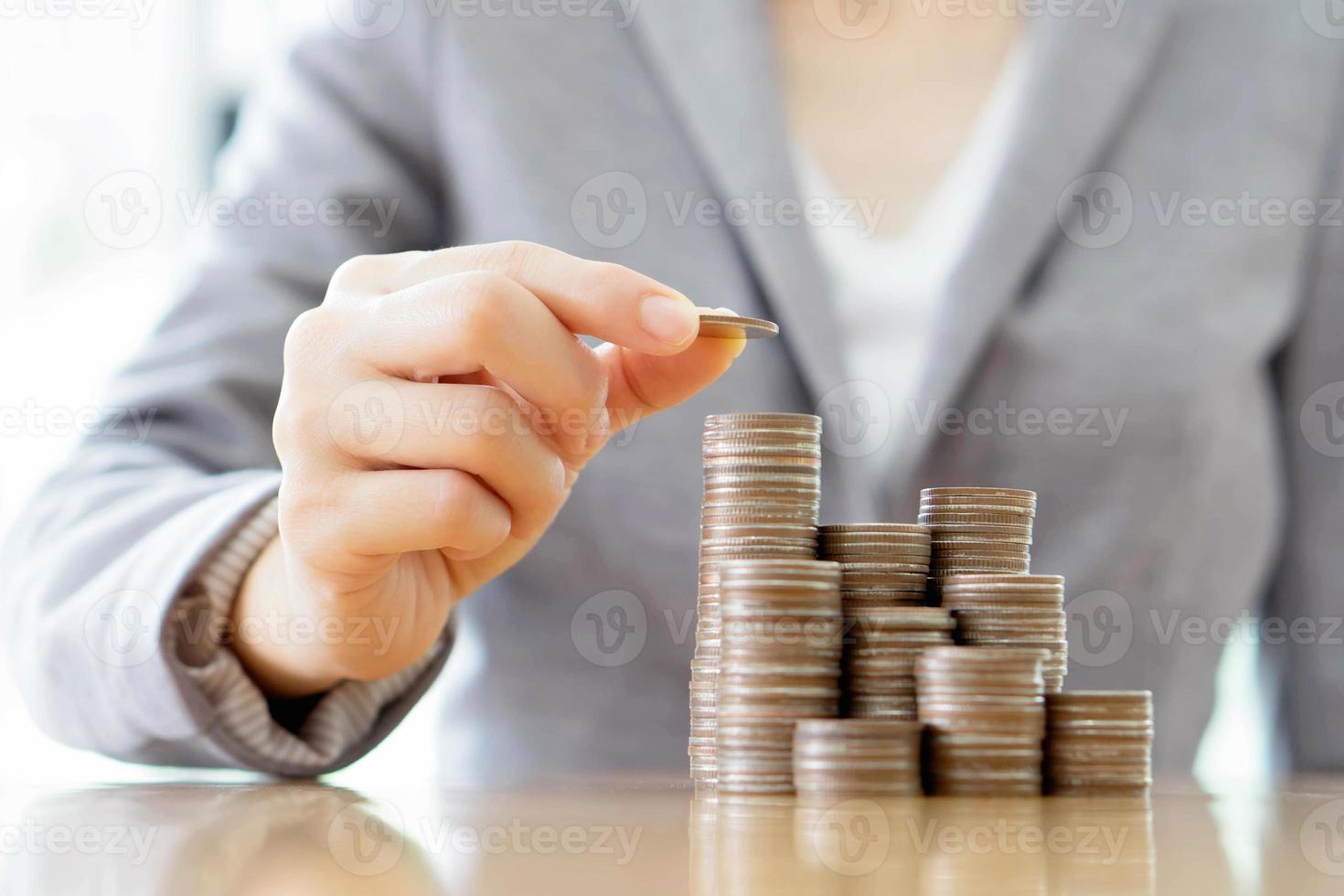 Close-up Of A Businesswoman Making Stack Of Coins photo