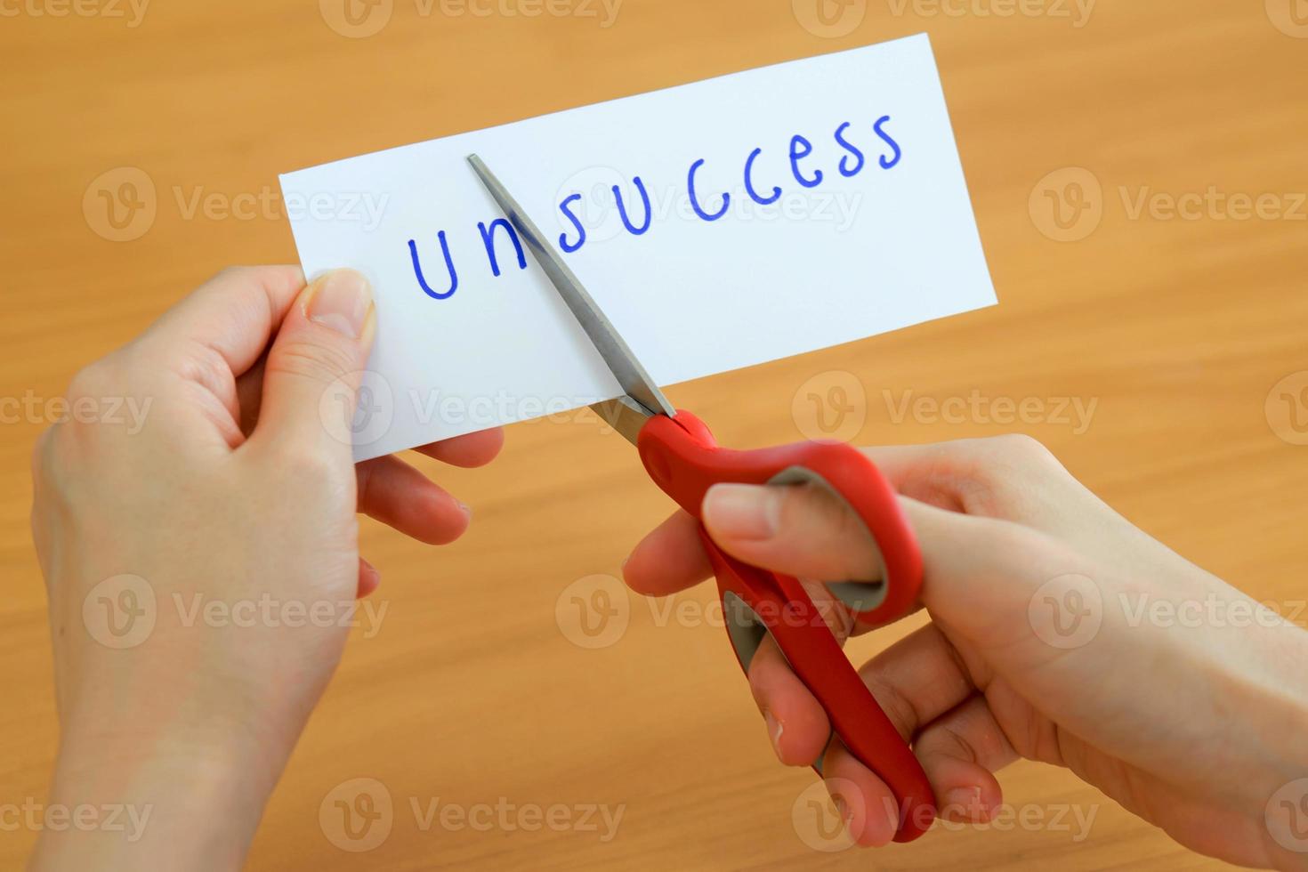 holds card with text unsuccess on wood plate photo