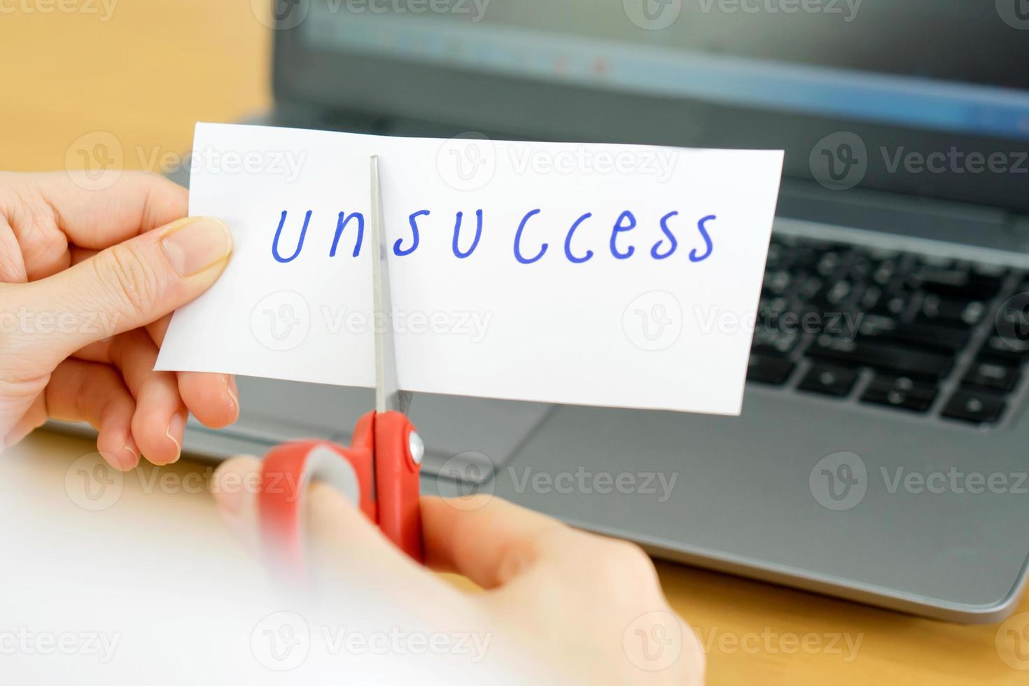 holds card with text unsccess on computer photo
