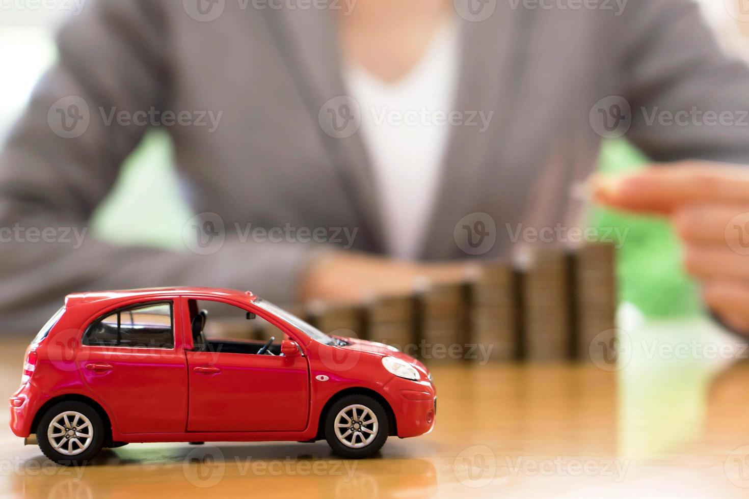 Businesswoman a toy car and a stack of coins photo