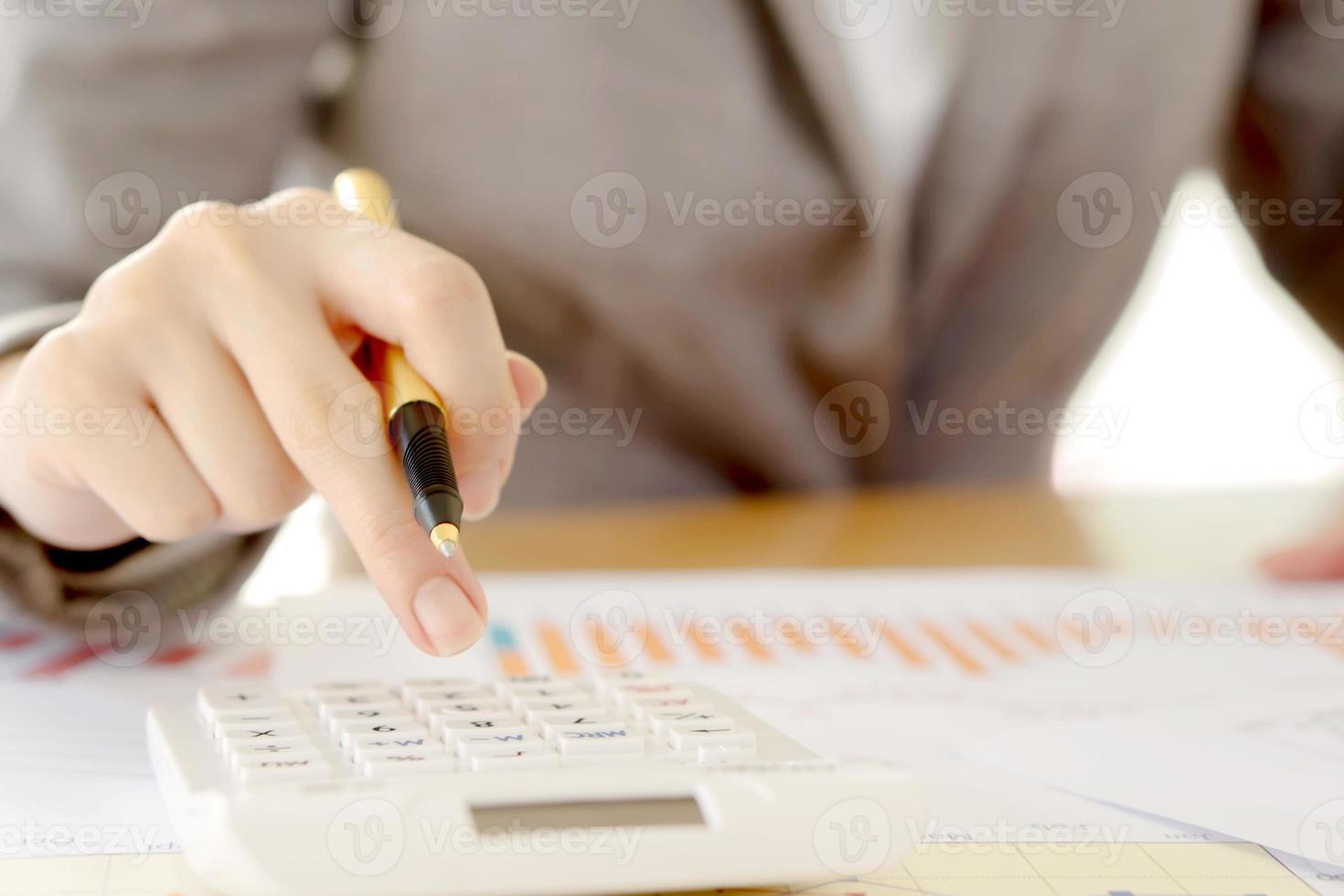 Close up of female accountant or banker making calculations. Savings, finances and economy concept photo