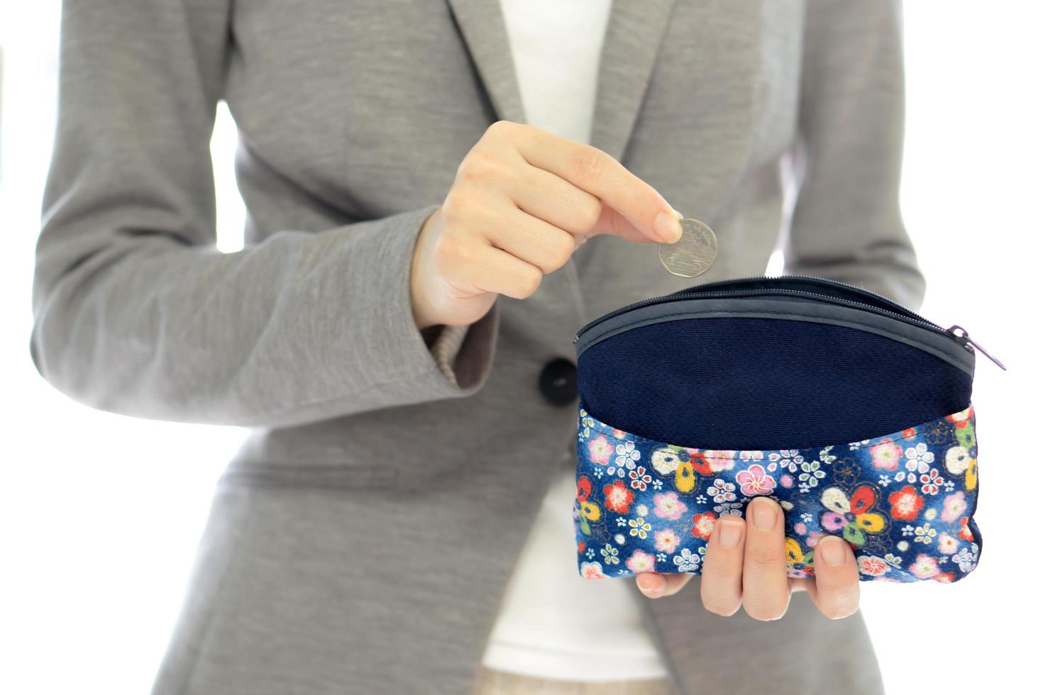 Businesswomen hands holding british coin and small money pouch photo