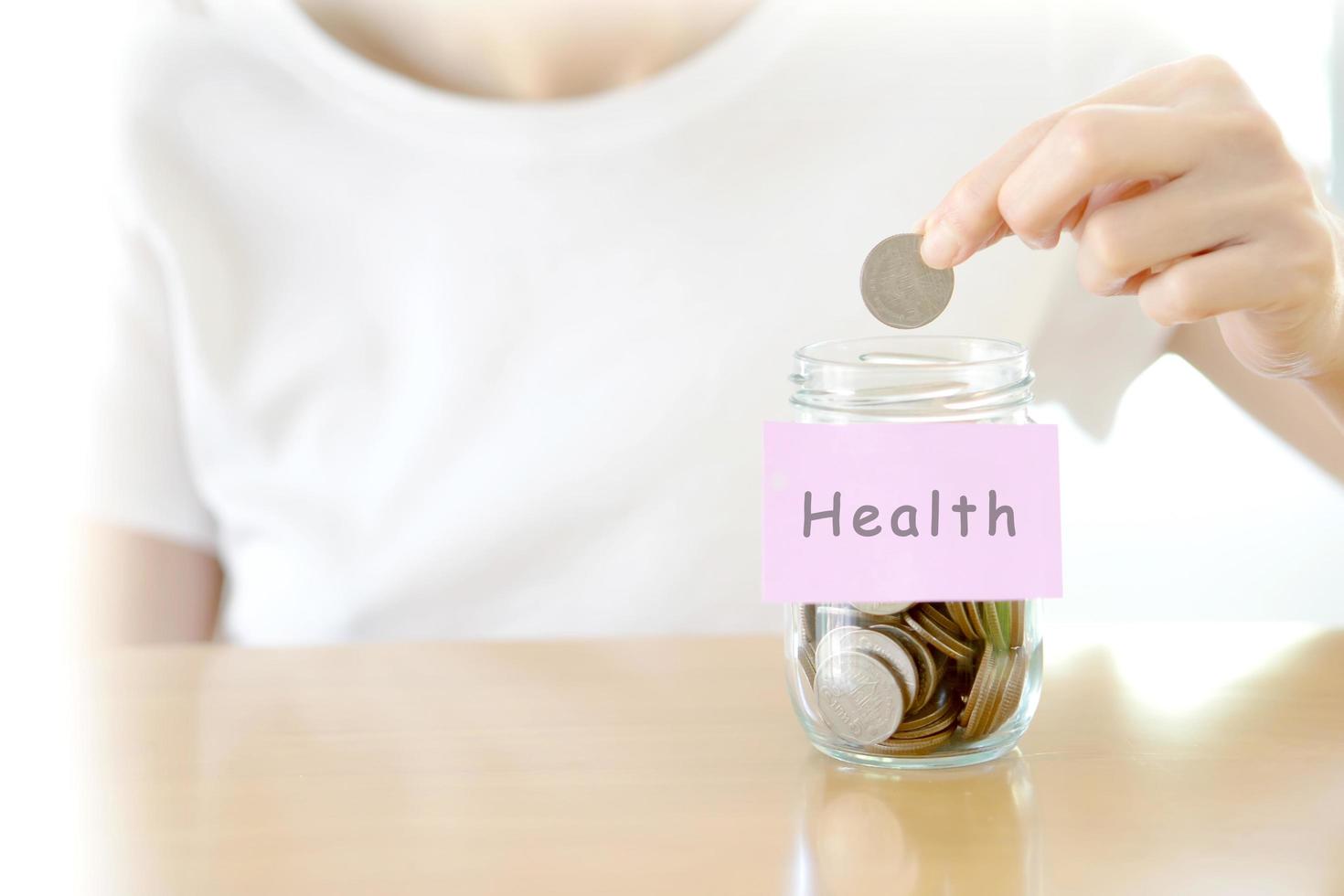 Woman hands with coins in glass jar, close up photo