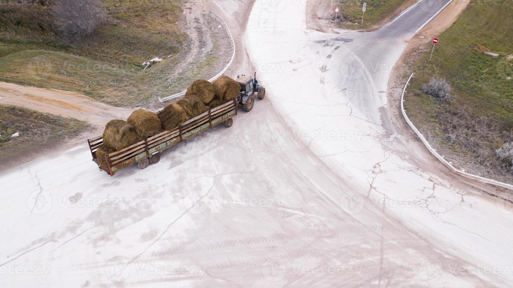 the tractor carries the bales of straw photo