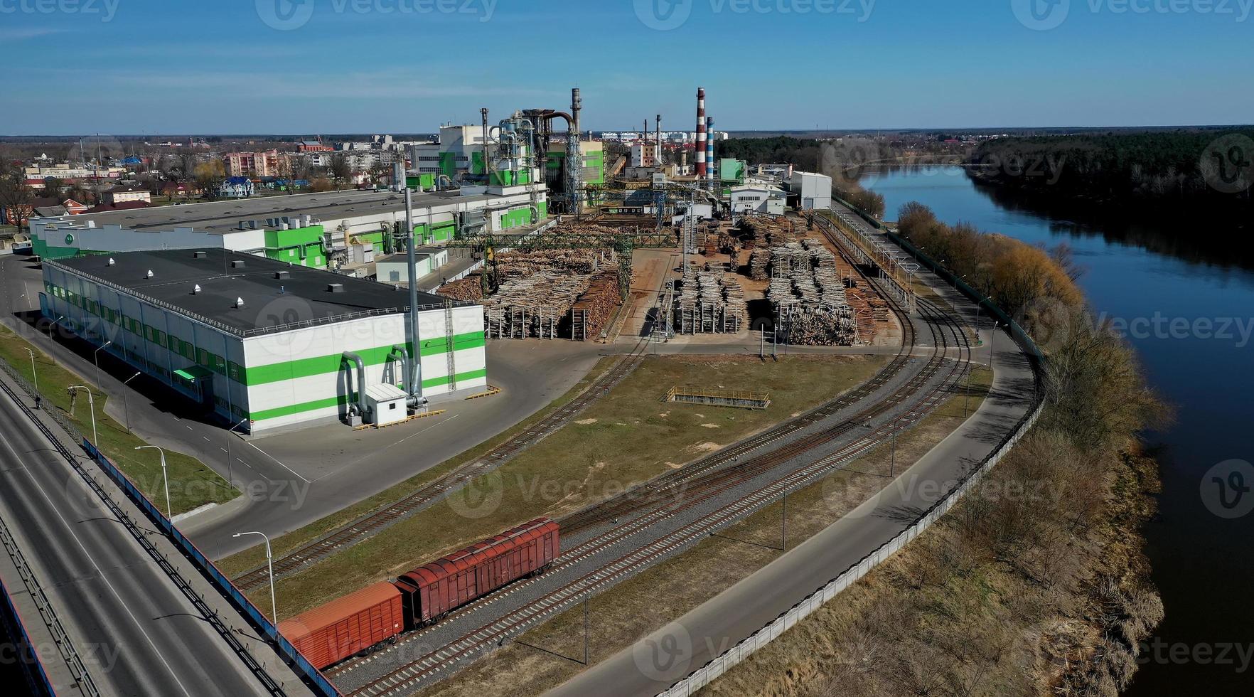 pipes of woodworking enterprise plant sawmill near river. Air pollution concept. Industrial landscape environmental pollution waste of thermal power plant photo