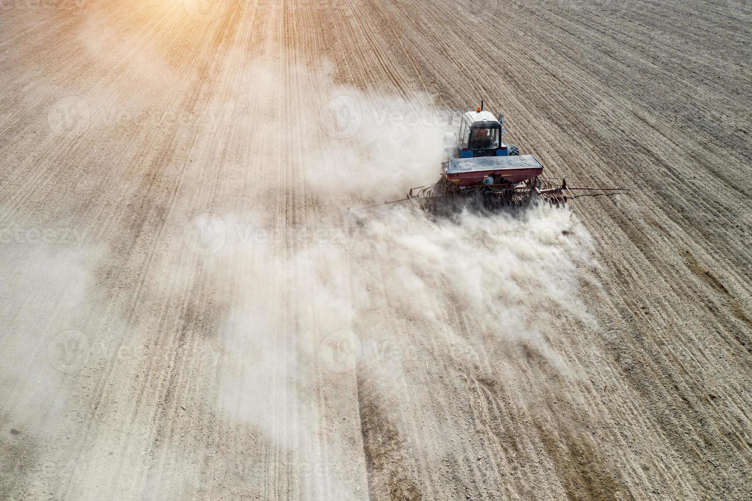 Farmer seeding, sowing crops at field. Sowing is the process of planting seeds in the ground as part of the early spring time agricultural activities. photo