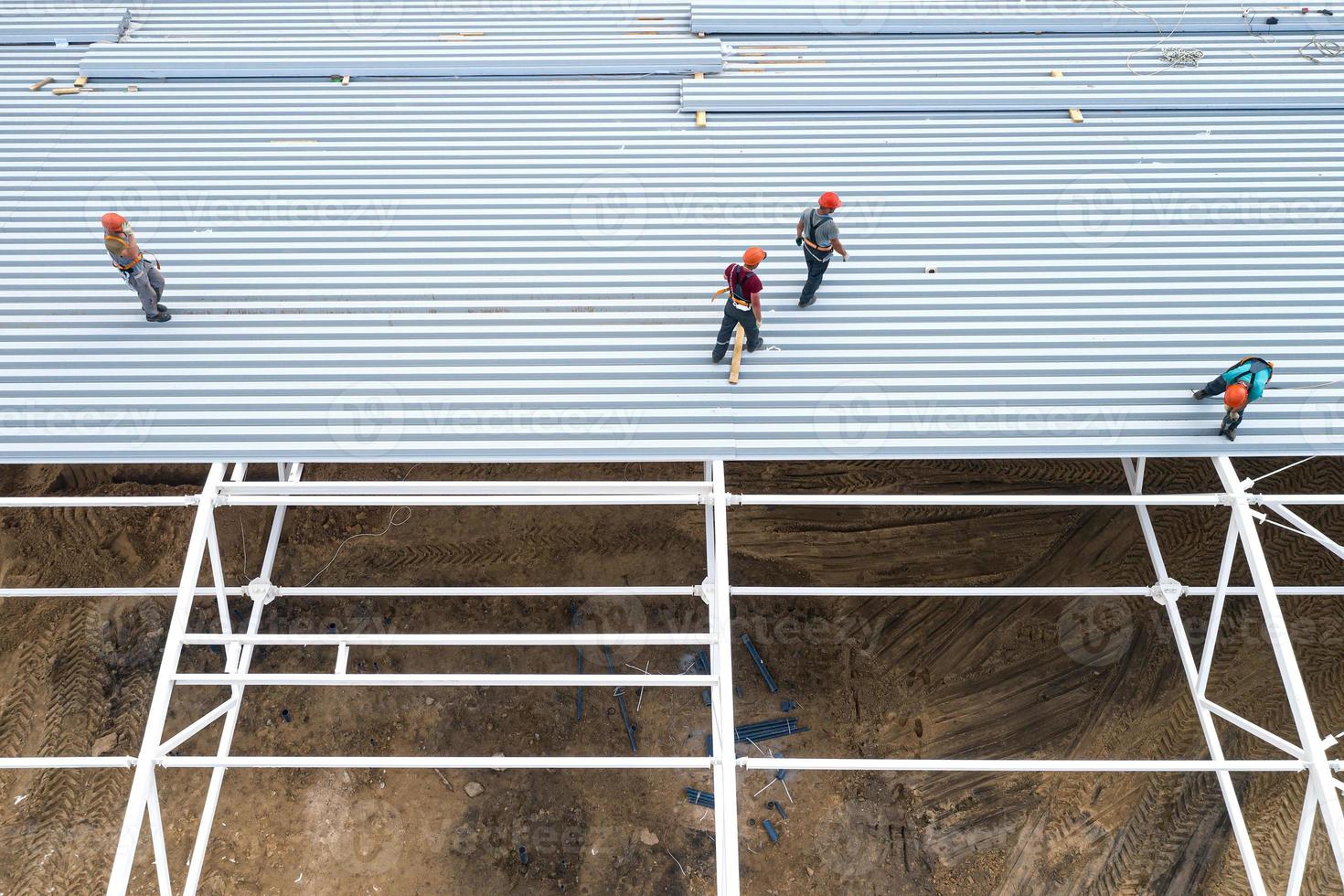 los trabajadores instalan el techo de un edificio moderno. vista superior desde un dron. foto