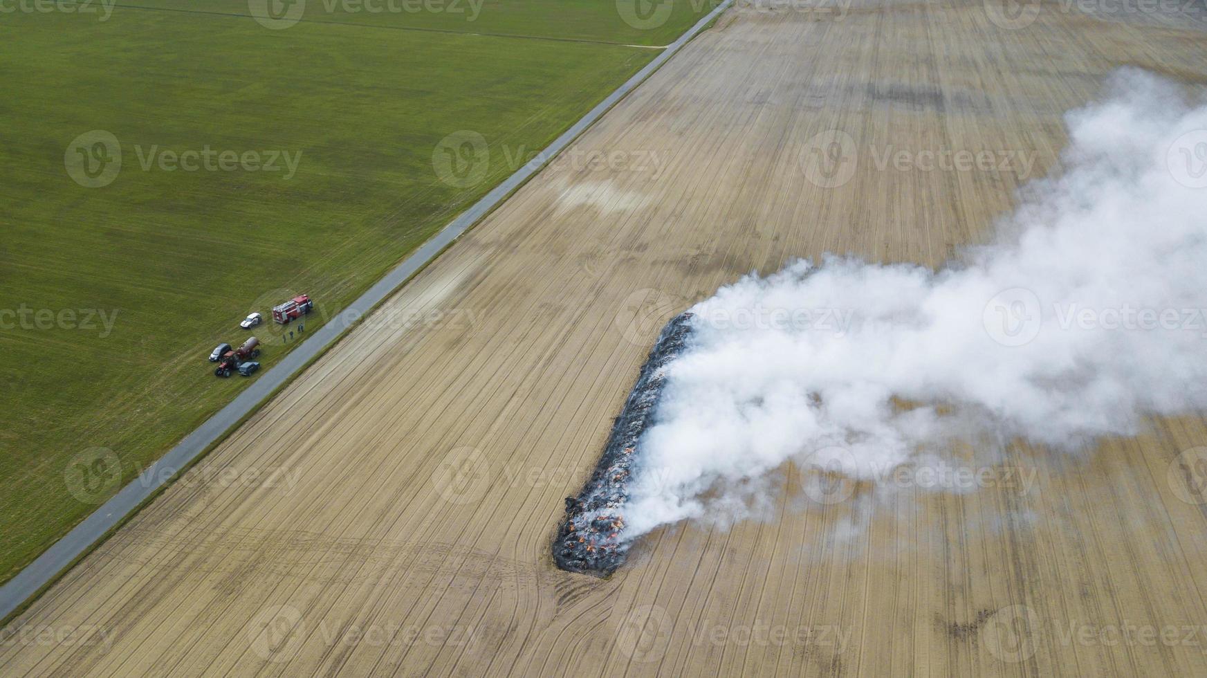 Aerial view of burnt land in the field after fire with ash and smoke photo