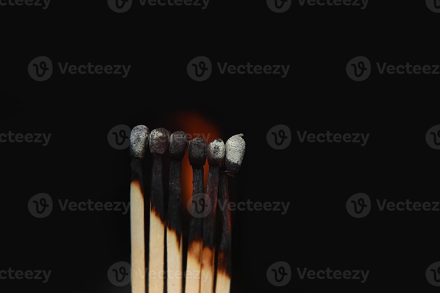 Burning matches on black background. matchsticks on fire in row of burning is sequence while one match stay down from burning to avoid fire connecting against black background photo