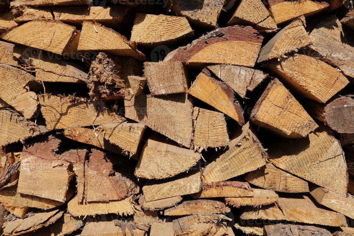 texture of pine firewood. Chipped firewood is on the heap. Woodpile of firewood close-up. A stack of dry firewood, visible texture and cracks in the tree. selective focus. photo