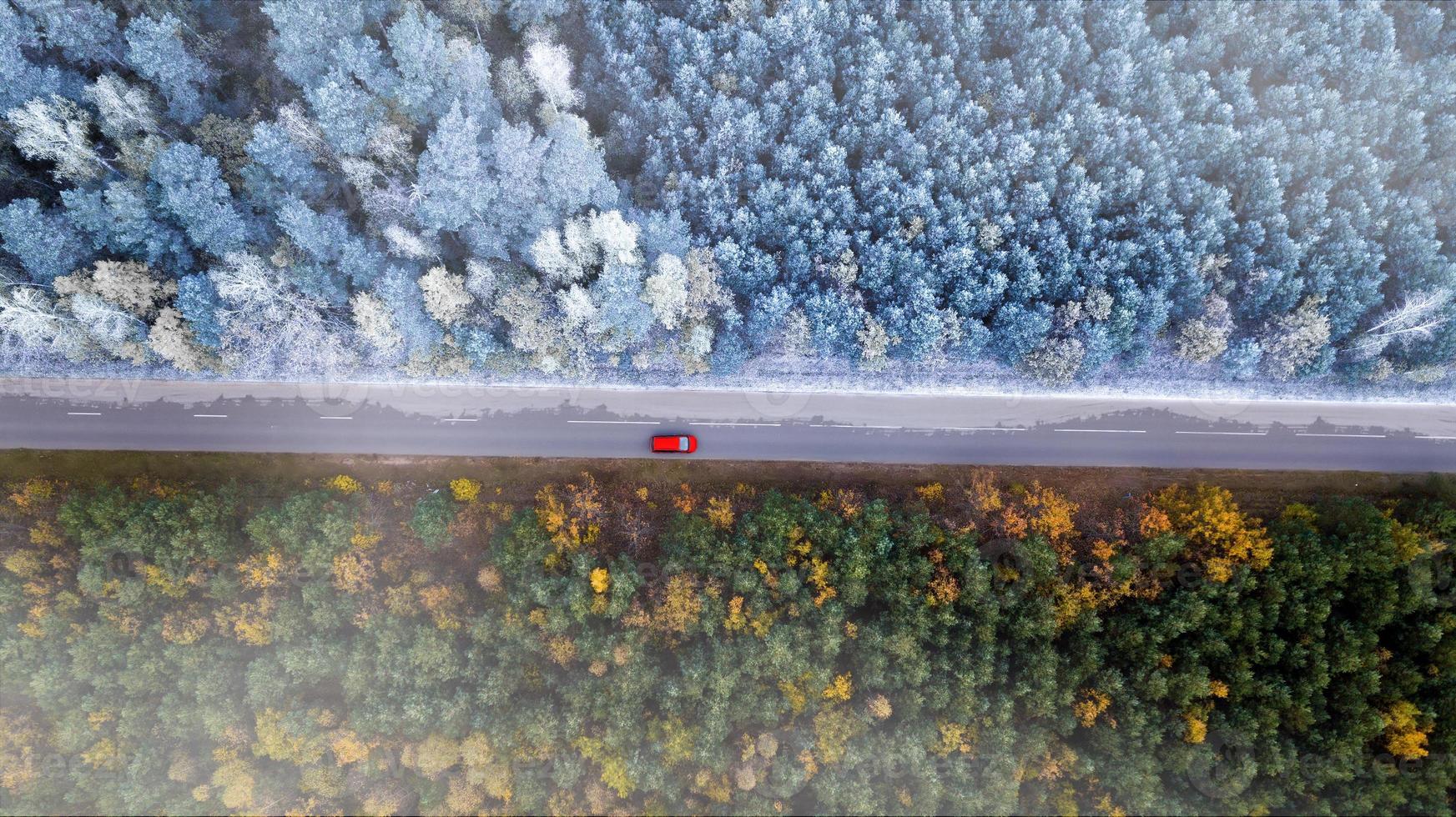 the border of autumn and winter. Car rides on the road in the forest top view from the drone. photo