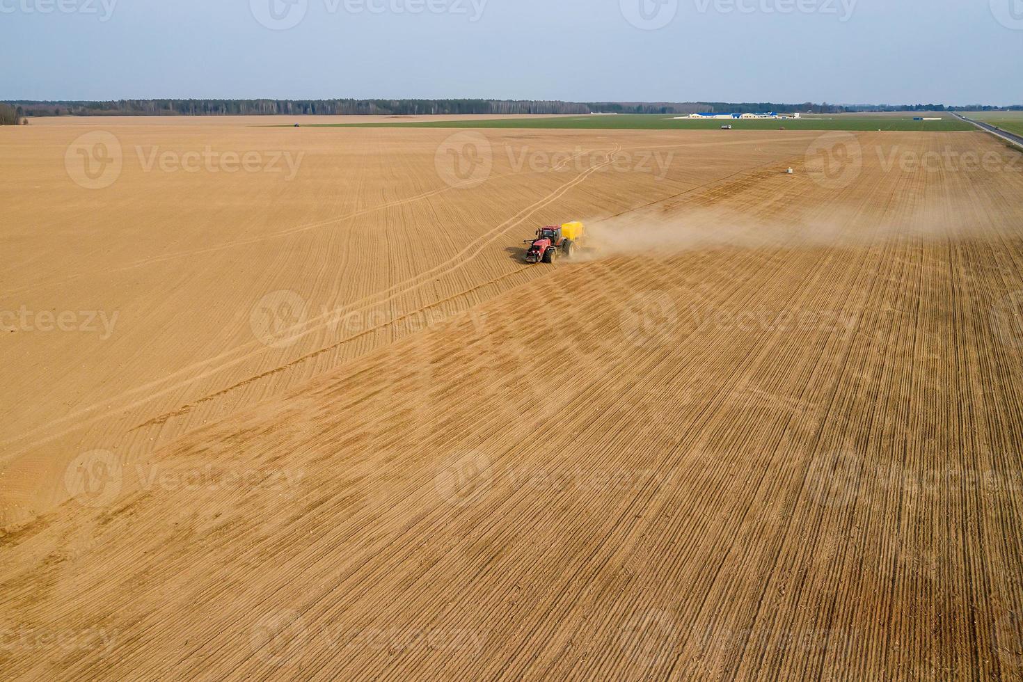tractor sows wheat in the field top view photo