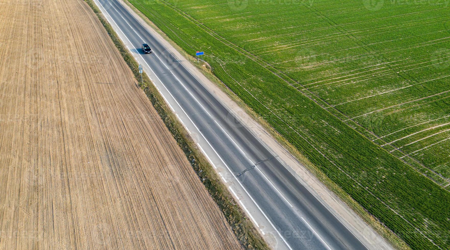 Aerial view of traffic on two lane road through countryside and cultivated fields photo