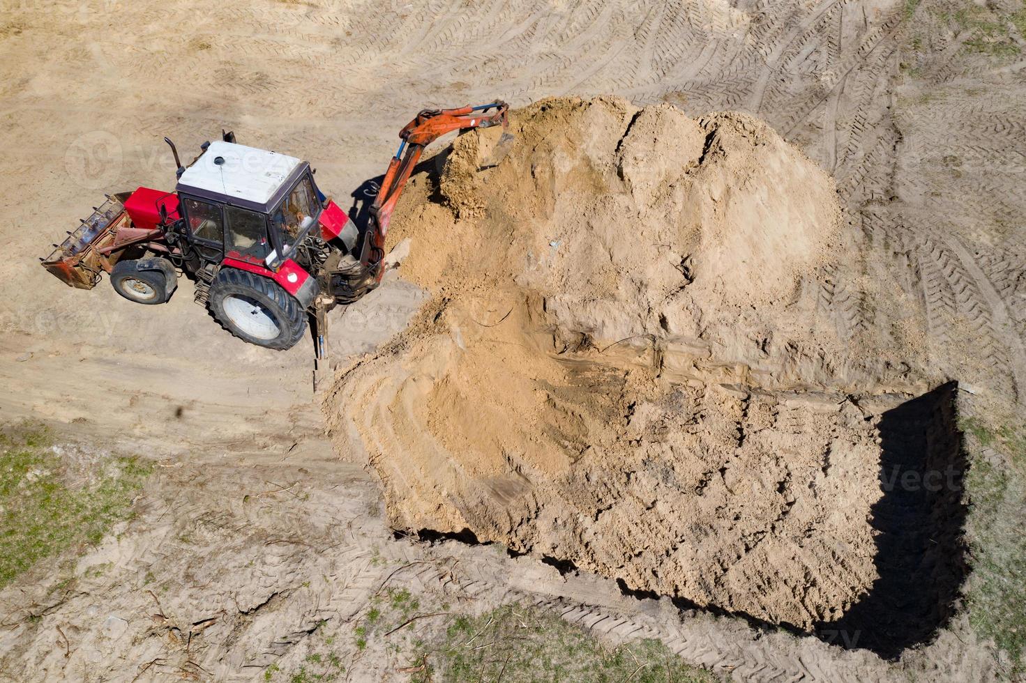 Excavator at work trenching at a construction site. Arial view. photo
