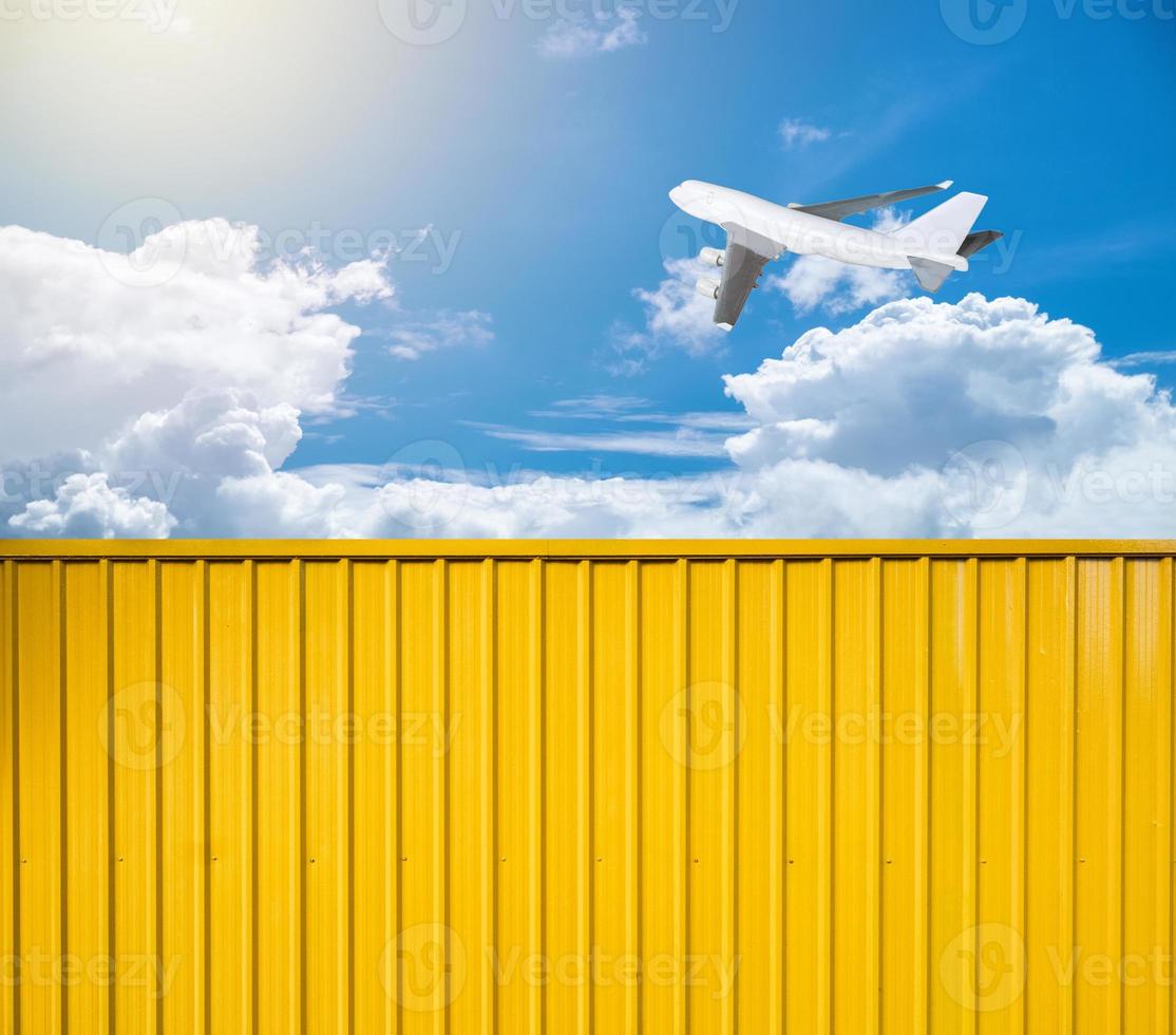 contenedor de caja amarilla con avión en el cielo foto