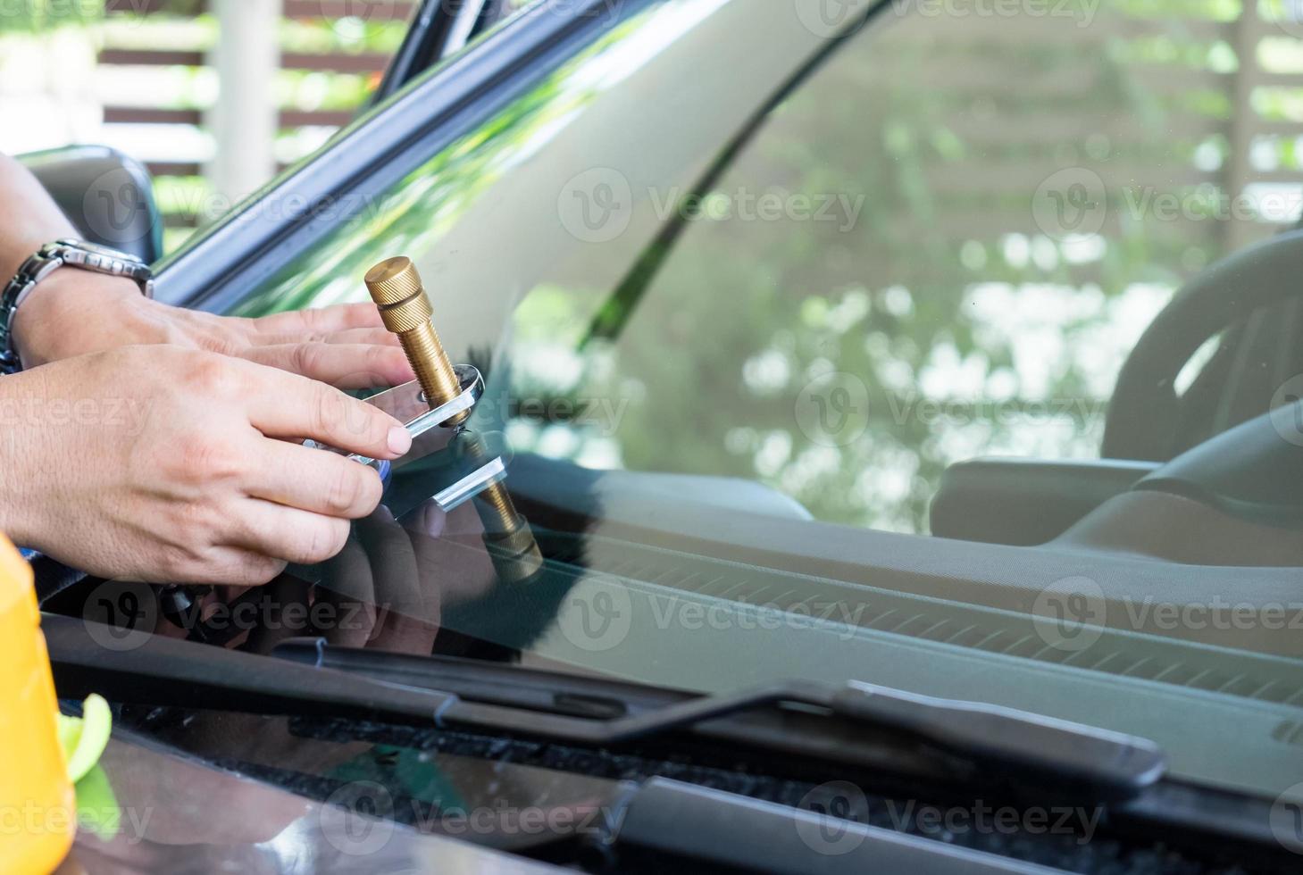 Glazier using tools repair to fix crack windshield photo