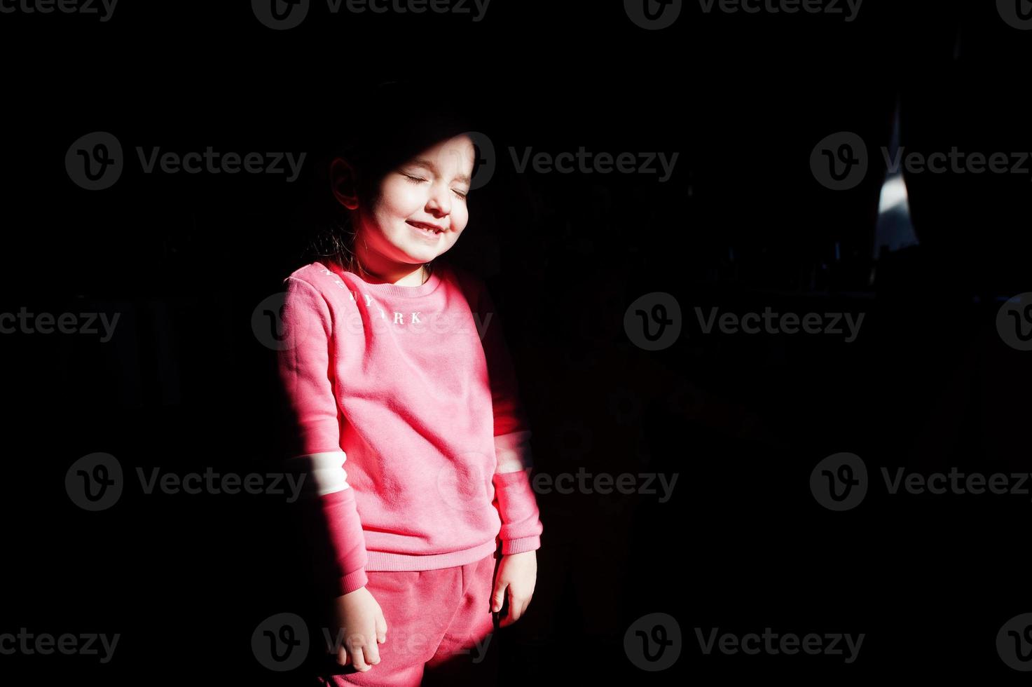 Little girl in the sun and shade smiling. photo