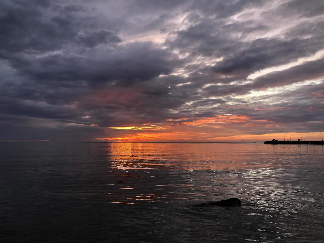 puesta de sol en el fondo de la vista al mar foto