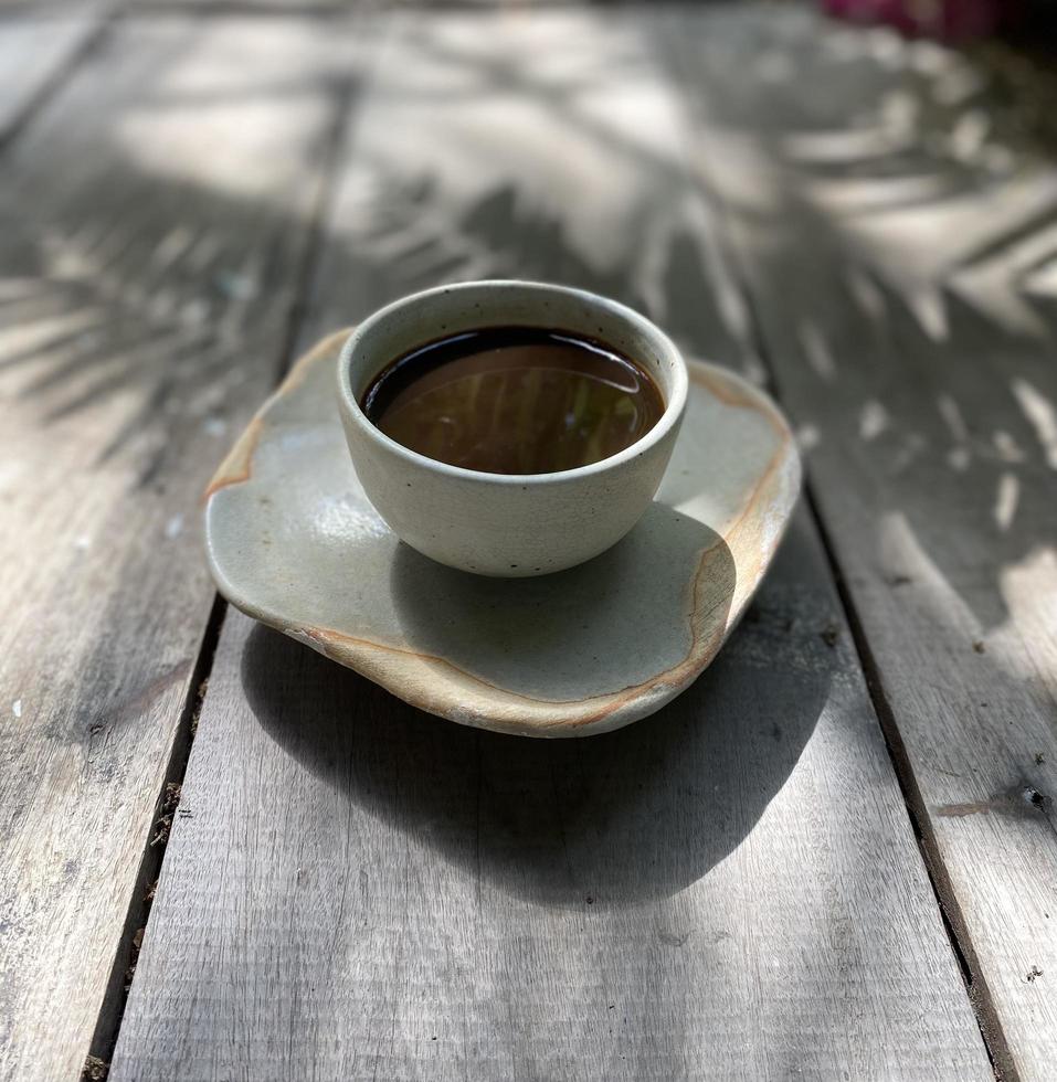 taza de café caliente en la mesa de madera foto