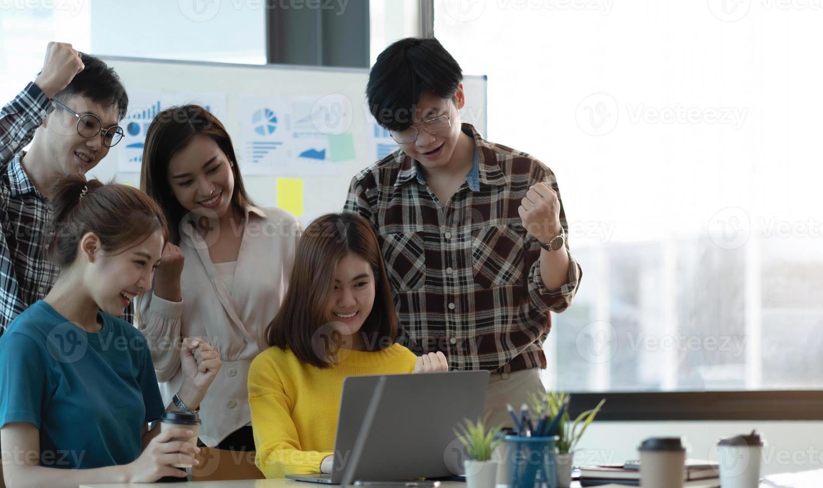 Asian creative people in modern office A new generation of business people are working with successful laptops, tablets, smartphones, notebooks. photo