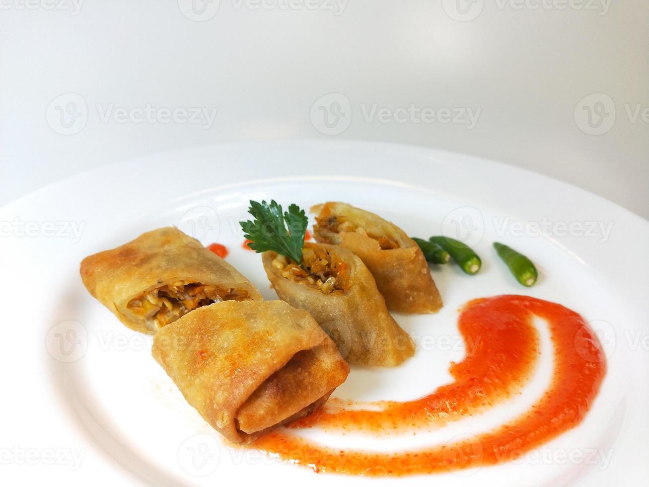 La lumpia es un refrigerio típico de Indonesia Central que consiste en una mezcla de brotes de bambú jóvenes, huevos, verduras frescas y carne o mariscos, en un rollo hecho de finas láminas de harina de trigo. foto