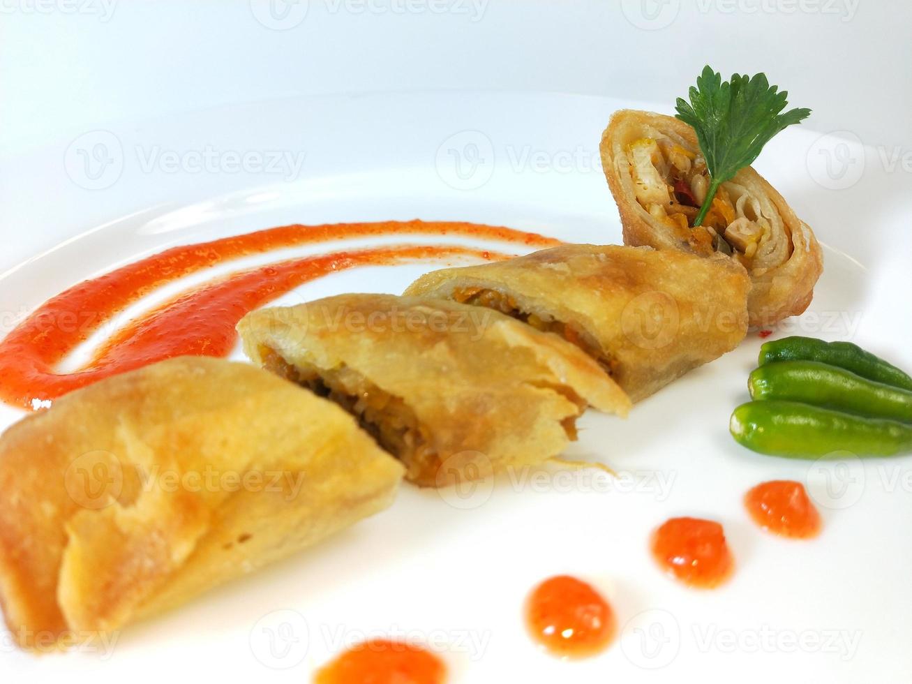 La lumpia es un refrigerio típico de Indonesia Central que consiste en una mezcla de brotes de bambú jóvenes, huevos, verduras frescas y carne o mariscos, en un rollo hecho de finas láminas de harina de trigo. foto