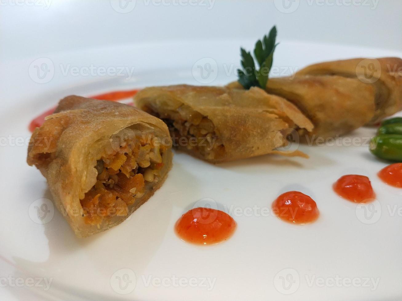 Lumpia is a typical Central Javanese Indonesian snack consisting of a mixture of young bamboo shoots, eggs, fresh vegetables, and meat or seafood, in a roll made of thin sheets of wheat flour photo