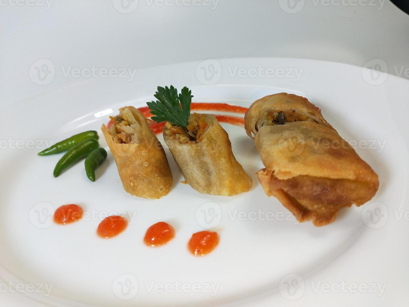 La lumpia es un refrigerio típico de Indonesia Central que consiste en una mezcla de brotes de bambú jóvenes, huevos, verduras frescas y carne o mariscos, en un rollo hecho de finas láminas de harina de trigo. foto