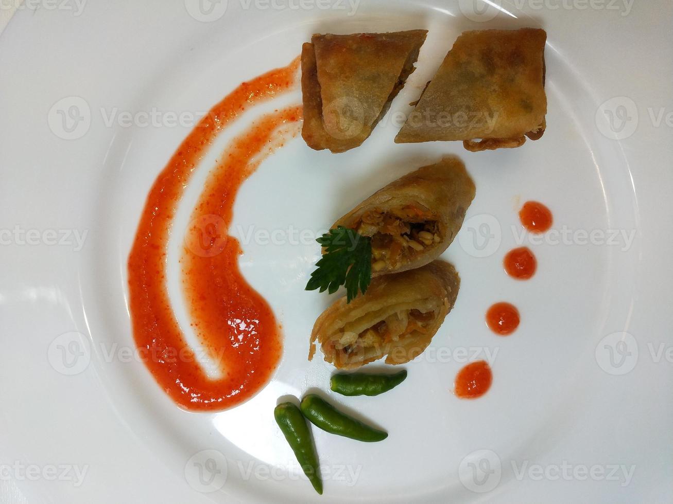 Lumpia is a typical Central Javanese Indonesian snack consisting of a mixture of young bamboo shoots, eggs, fresh vegetables, and meat or seafood, in a roll made of thin sheets of wheat flour photo