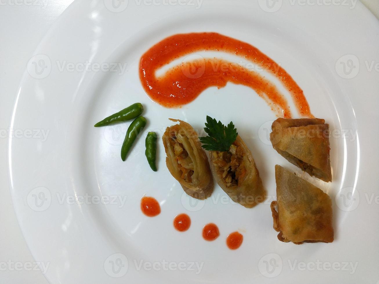 Lumpia is a typical Central Javanese Indonesian snack consisting of a mixture of young bamboo shoots, eggs, fresh vegetables, and meat or seafood, in a roll made of thin sheets of wheat flour photo