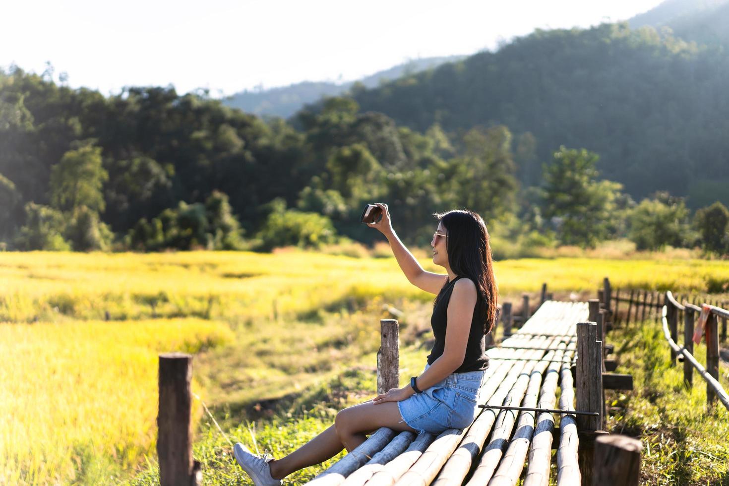 Solo traveller adult woman use smartphone at rice field. photo