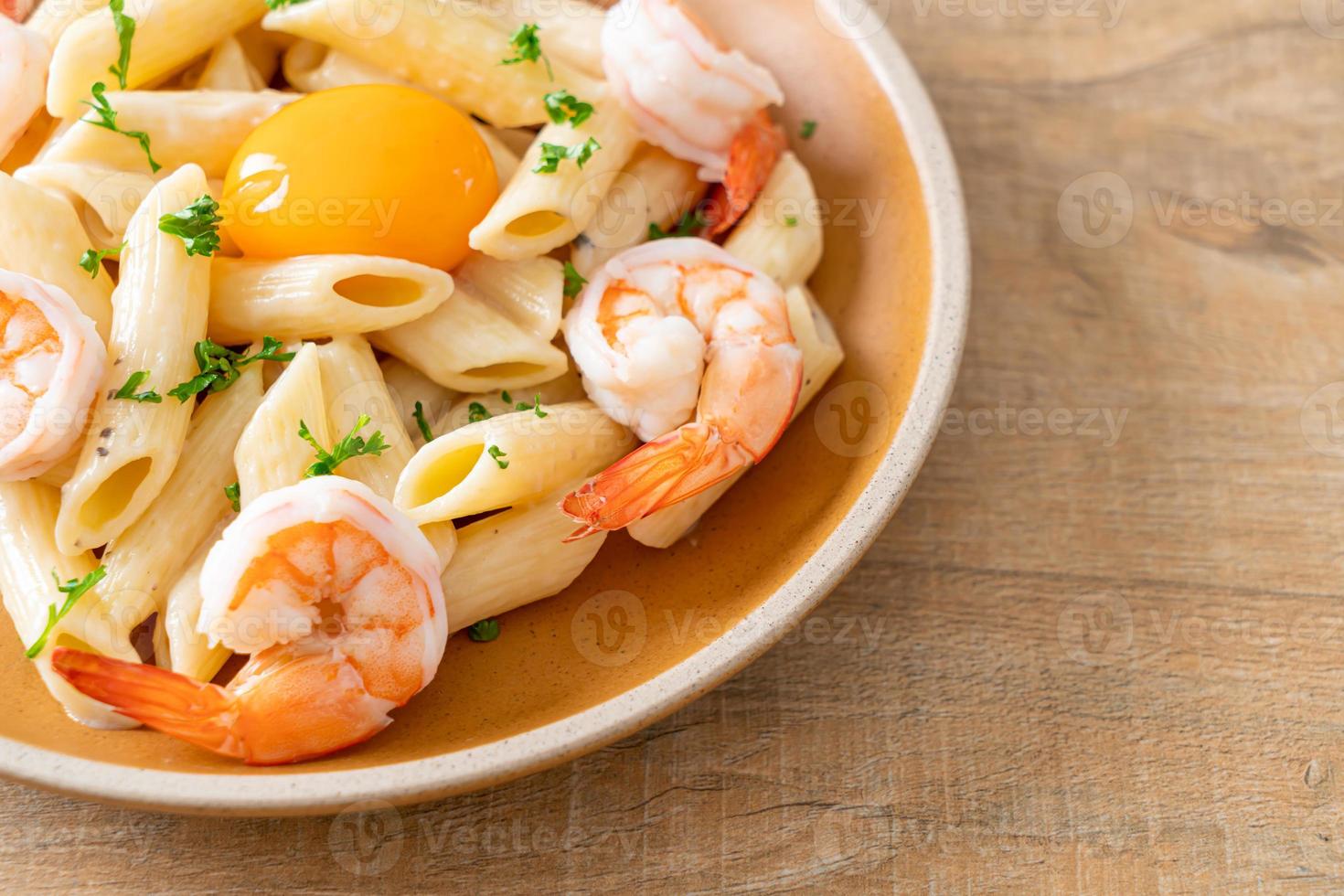 pasta penne salsa de crema blanca con gambas y huevo foto