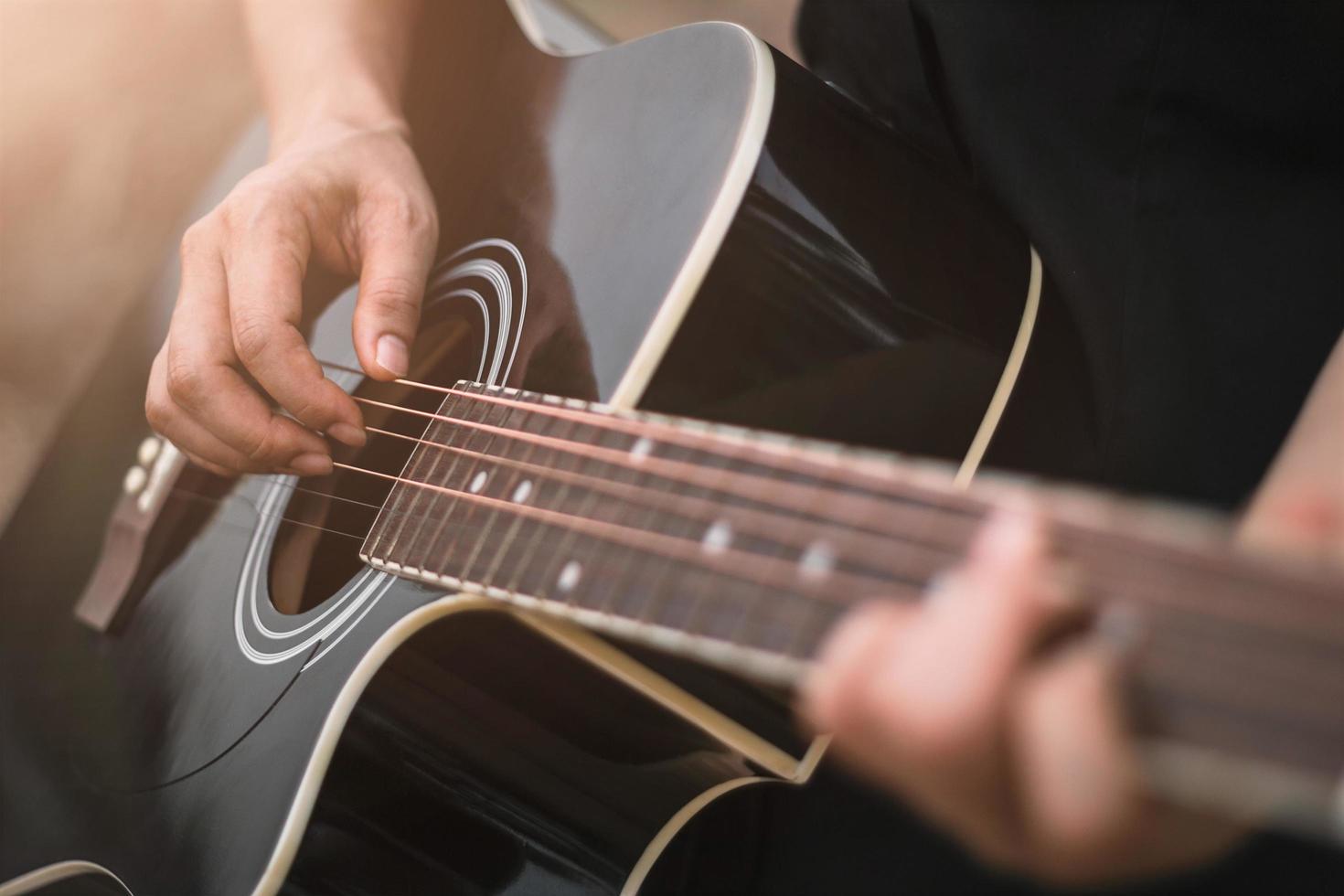 Guitar player playing acoustic guitar, close up photo