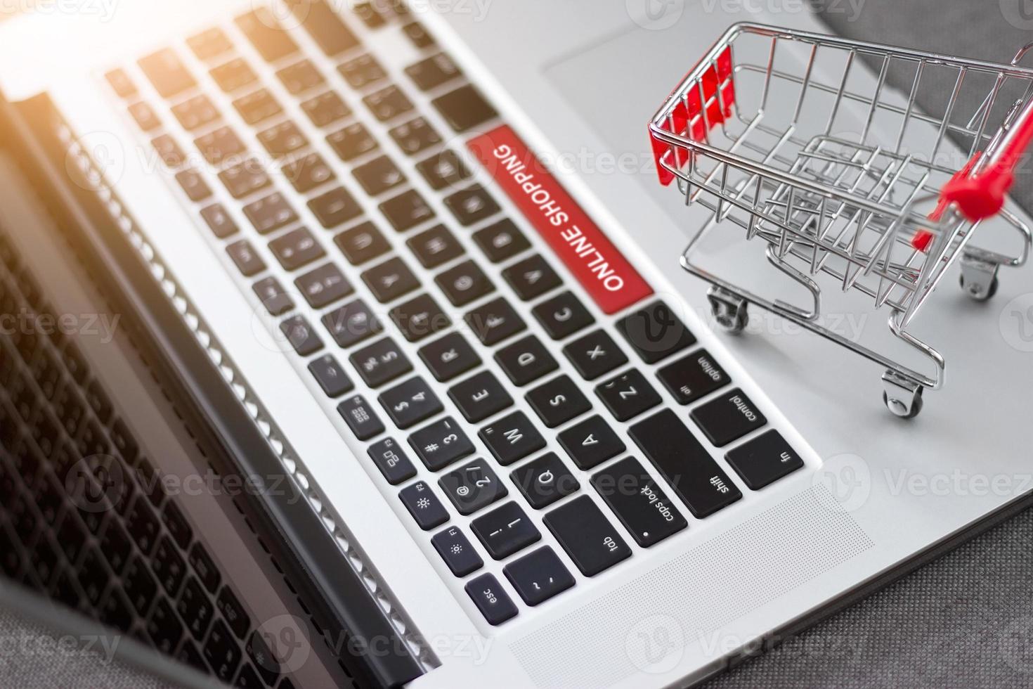 Shopping cart or trolley on laptop with text online shopping, network marketing business concept photo
