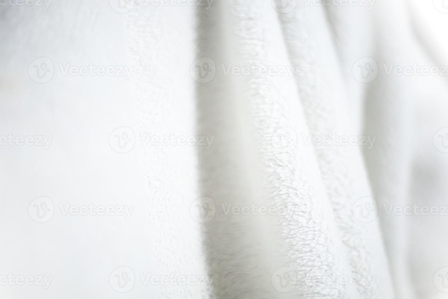 White shaggy blanket texture as background. Fluffy fake textile fur. photo