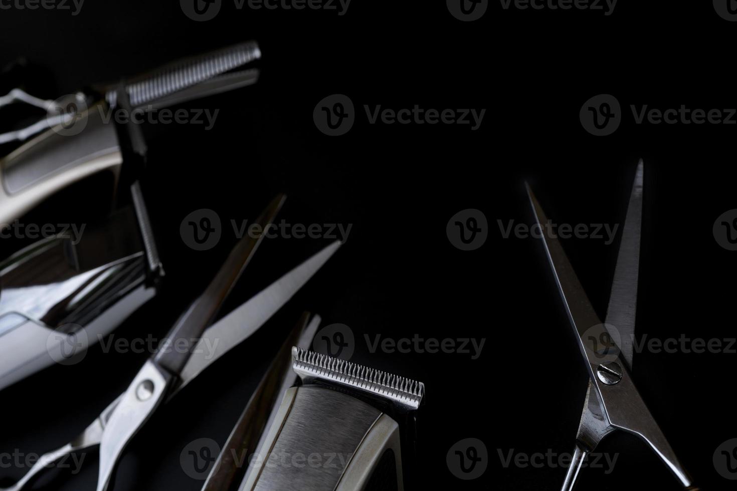 un conjunto de herramientas de corte de pelo sobre fondo negro para cortar el salón de barba de barbero foto