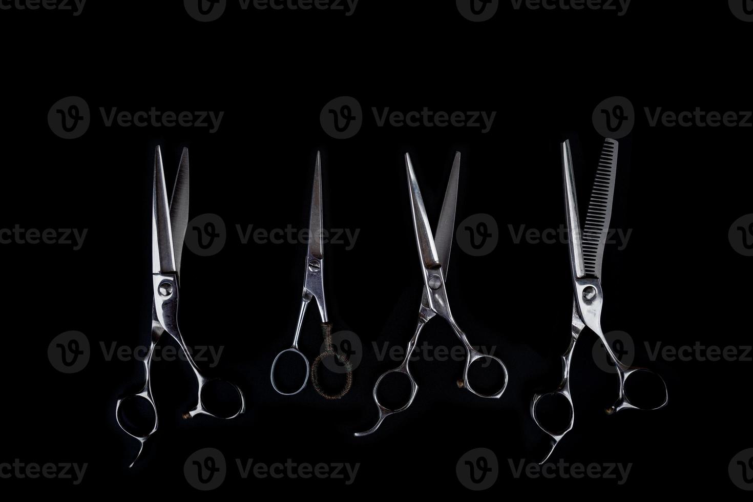 A set of hair cut tools on black background for cutting barber beard salon photo