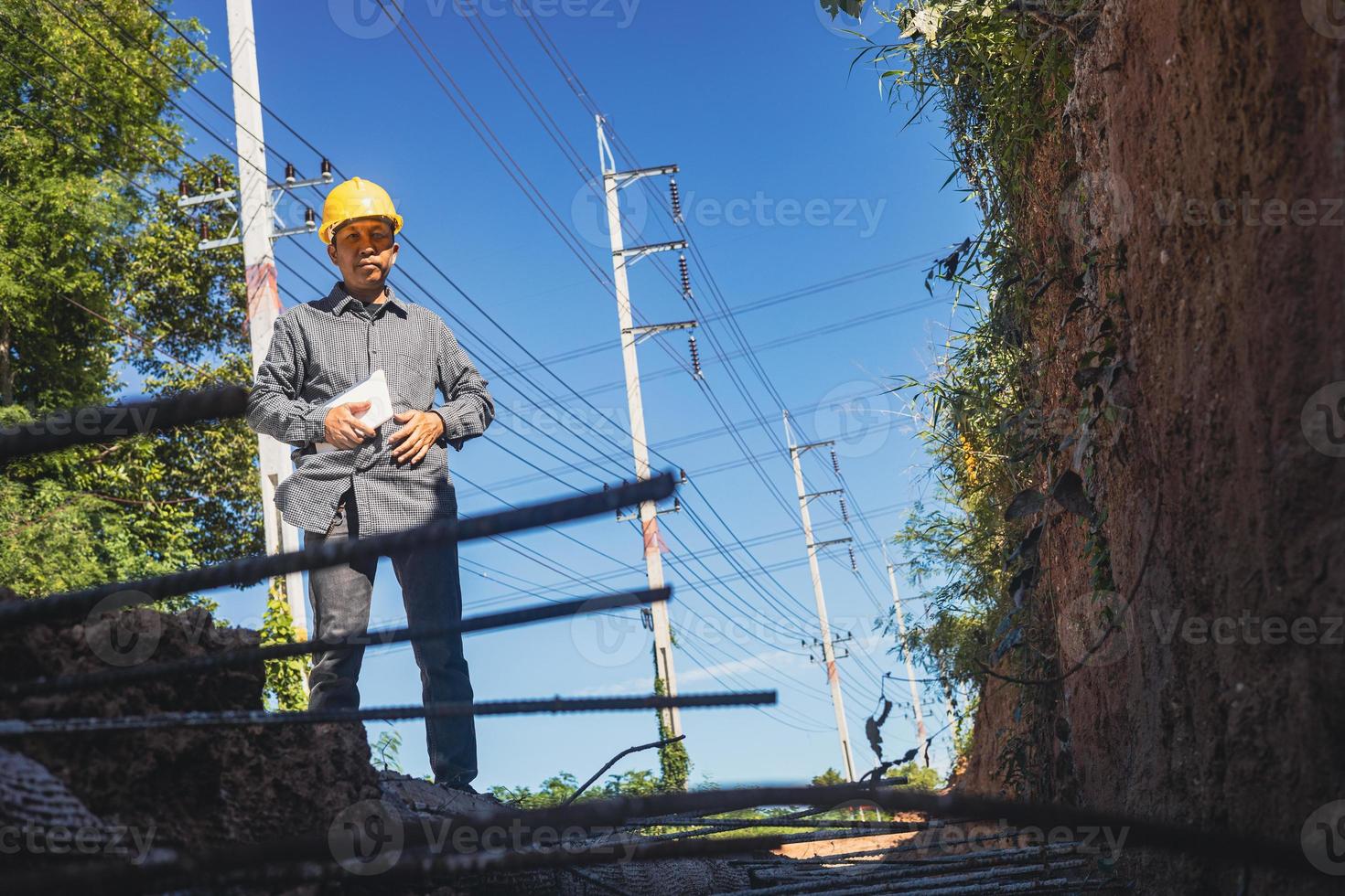 architect or civil engineer with hardhat on construction site checking schedule on tablet computer photo