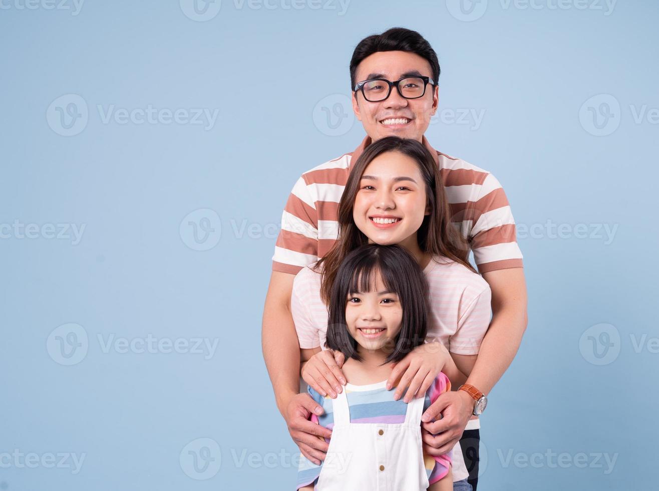 Portrait of young Asian family on background photo