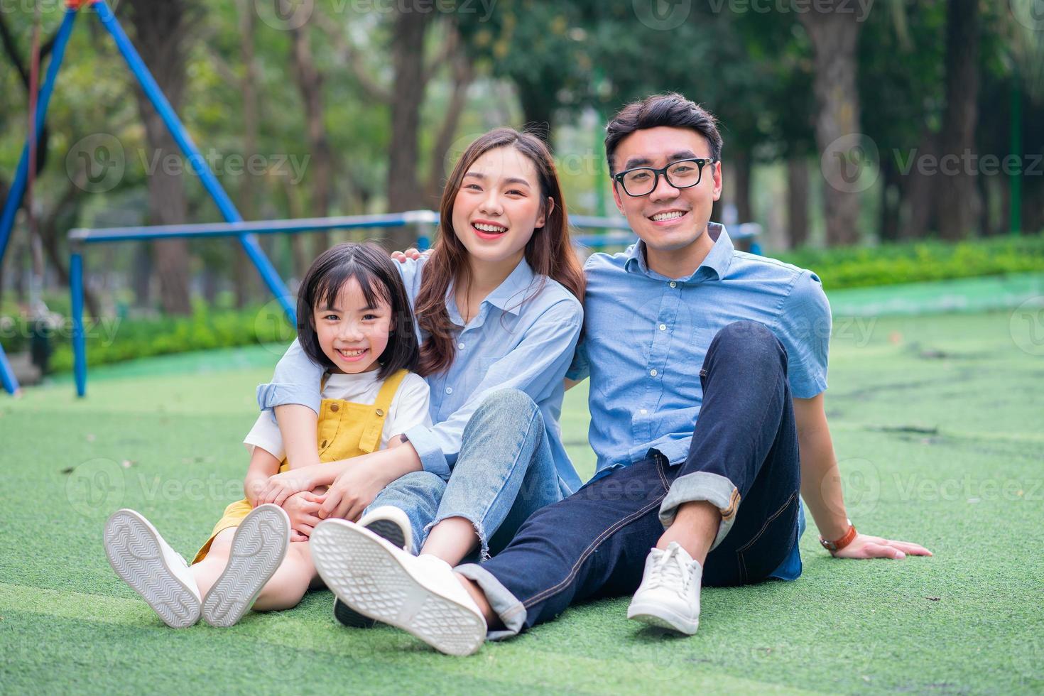 imagen de una joven familia asiática jugando juntos en el parque foto