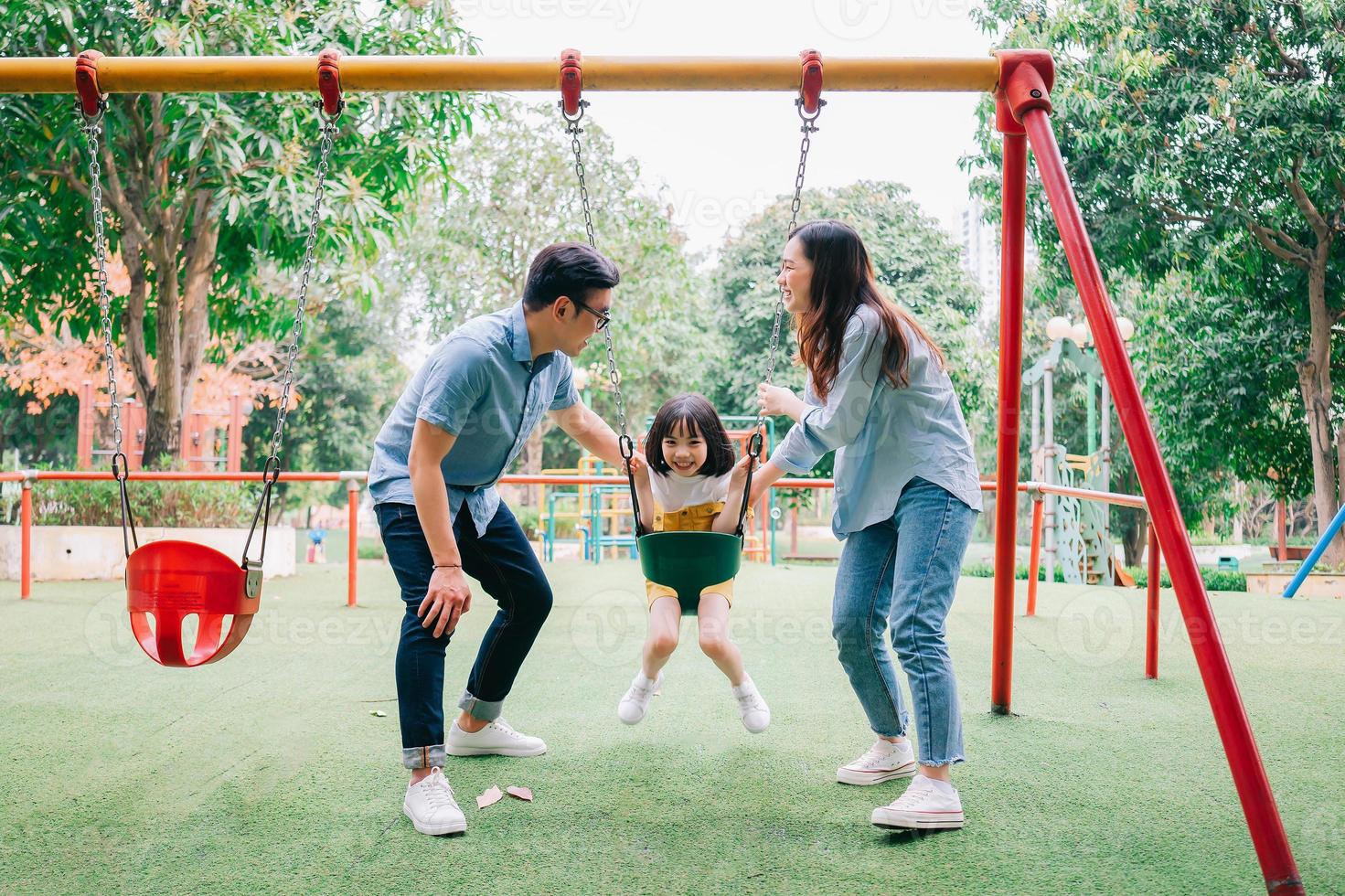 Image of young Asian family playing together at park photo