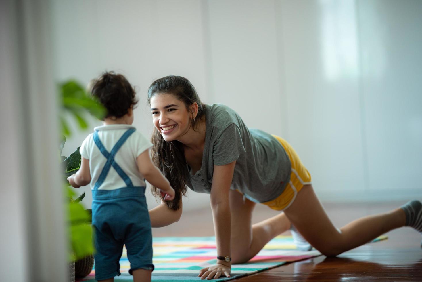 madre joven y bebé son felices en casa, concepto de familia infantil con madre caucásica y niño pequeño, estilo de vida de cuidado de recién nacidos foto